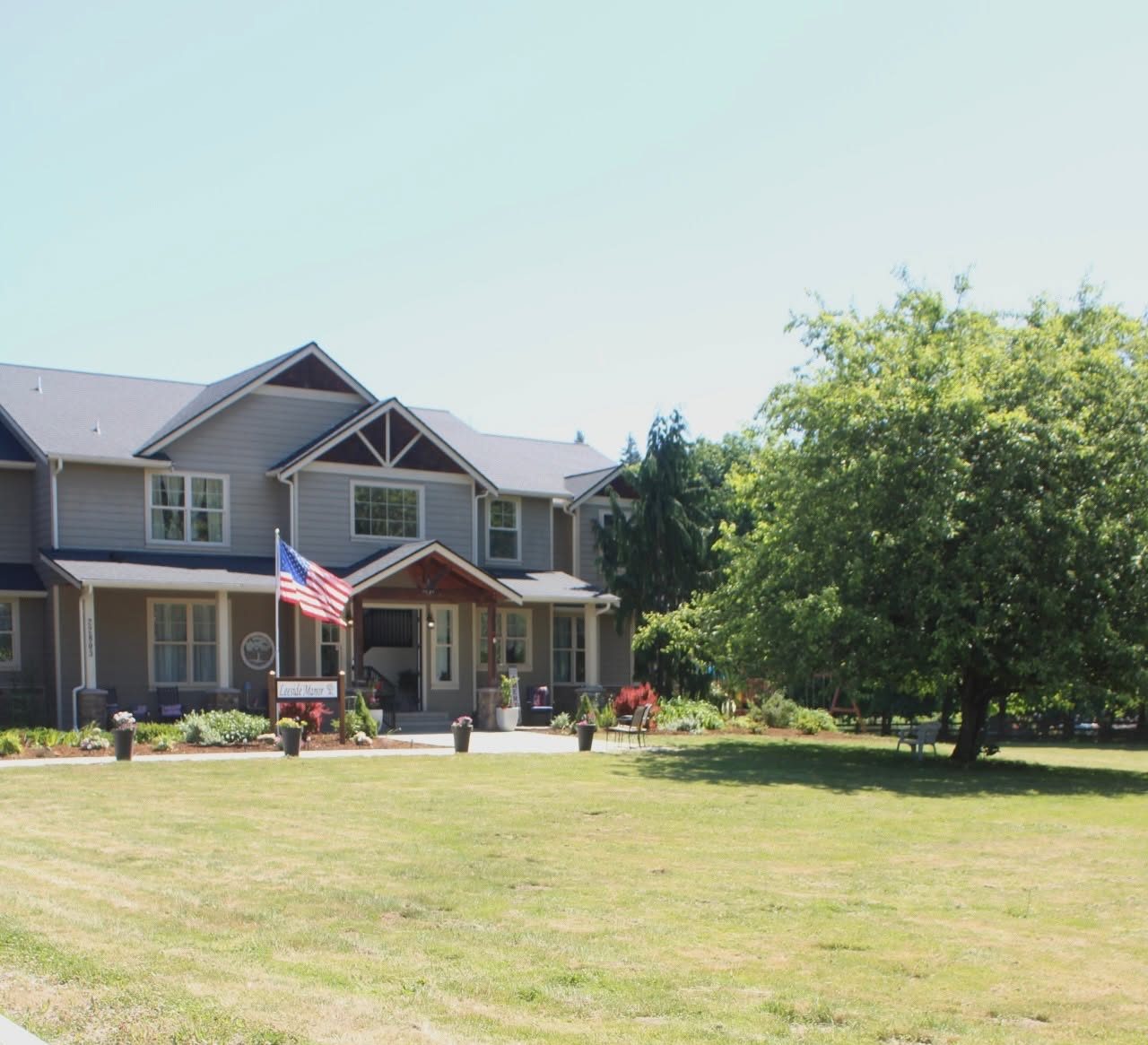 Leeside Manor on a clear day — the front of the home, its porch, and the five-acre lawn